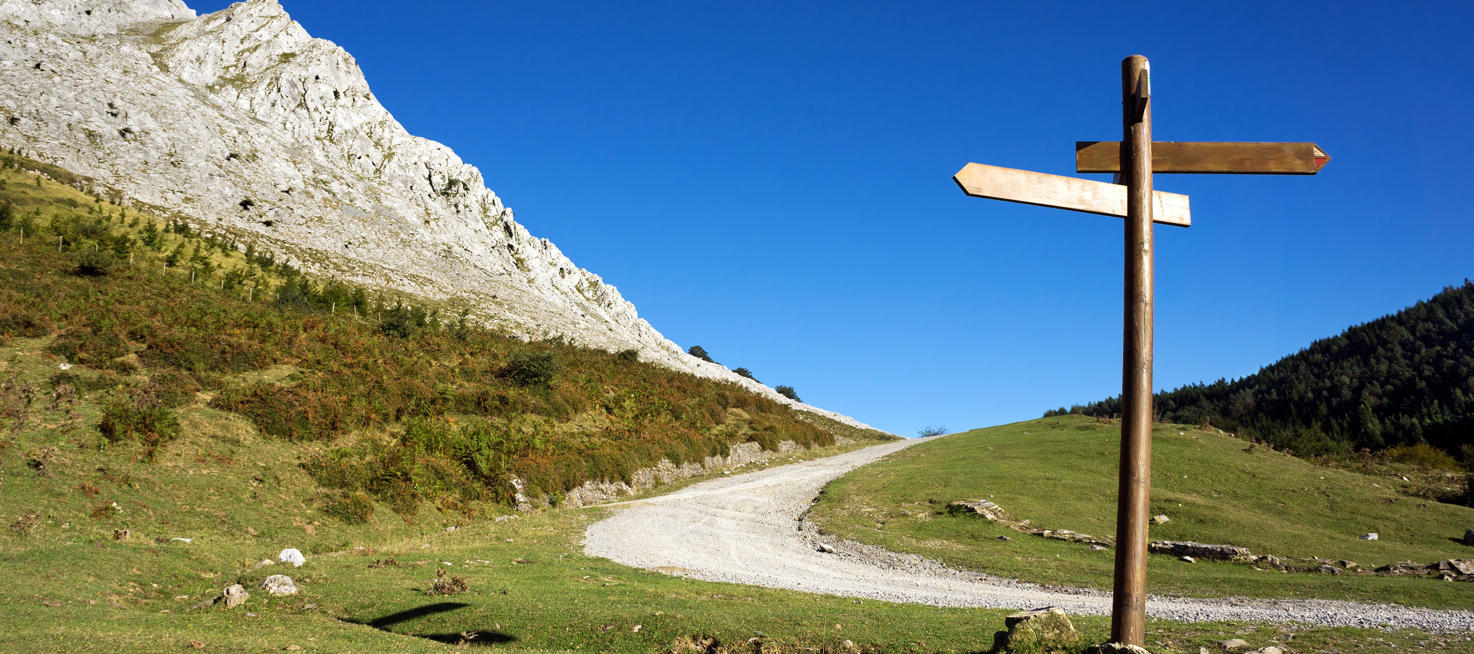 Ein Bergpfad mit einem Wegweißer-Schild